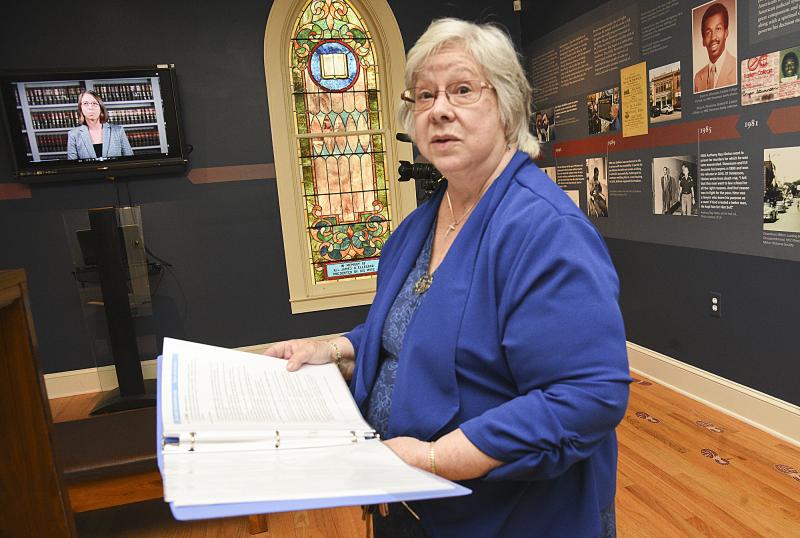 Lee Revis Plank shows a book that is housed in the podium that helps describe the conditions some of the prisoners endured.